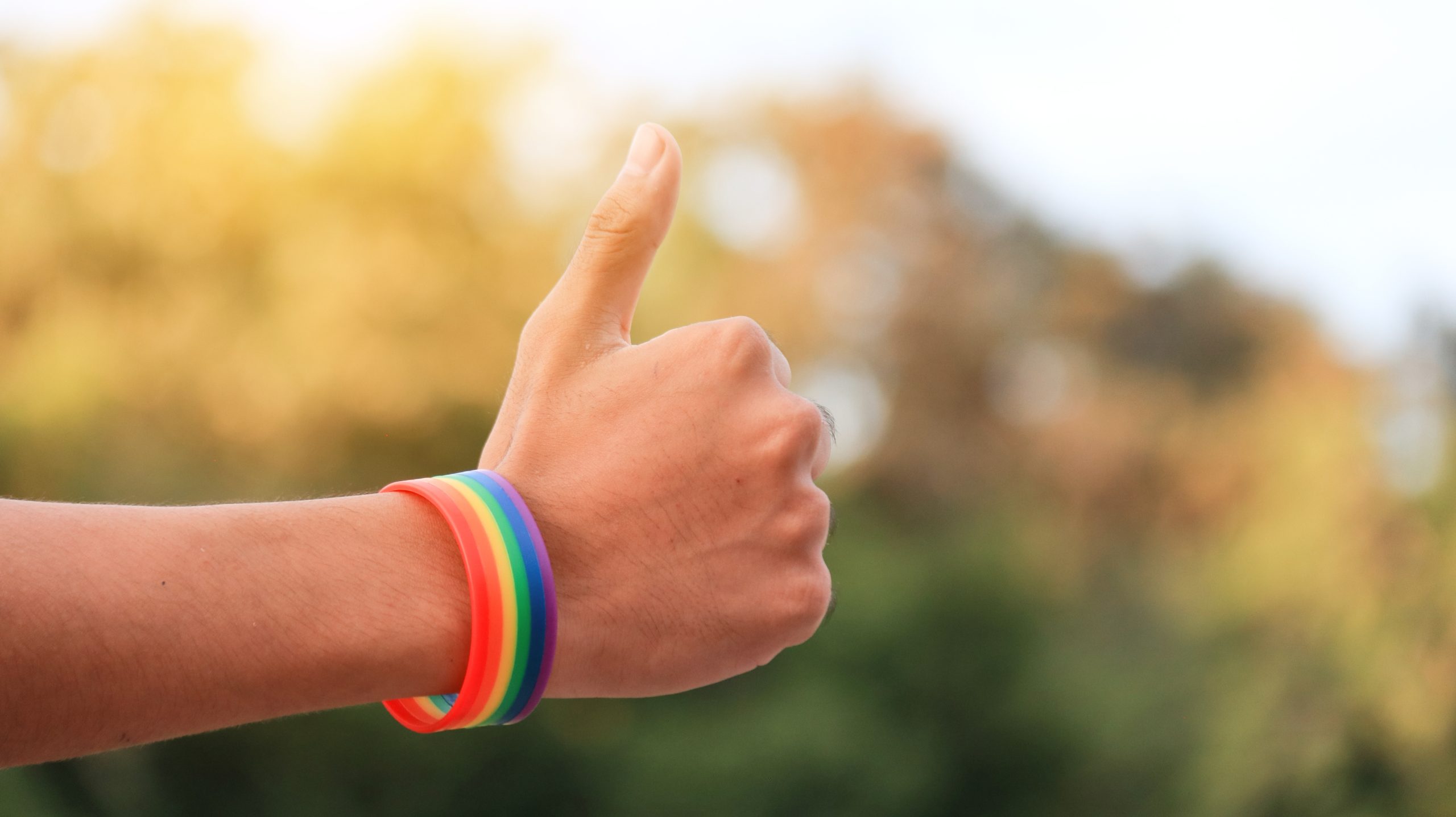 Hand,Which,Has,Rainbow,Wristband,On,Showing,Thumb,Up,,Soft