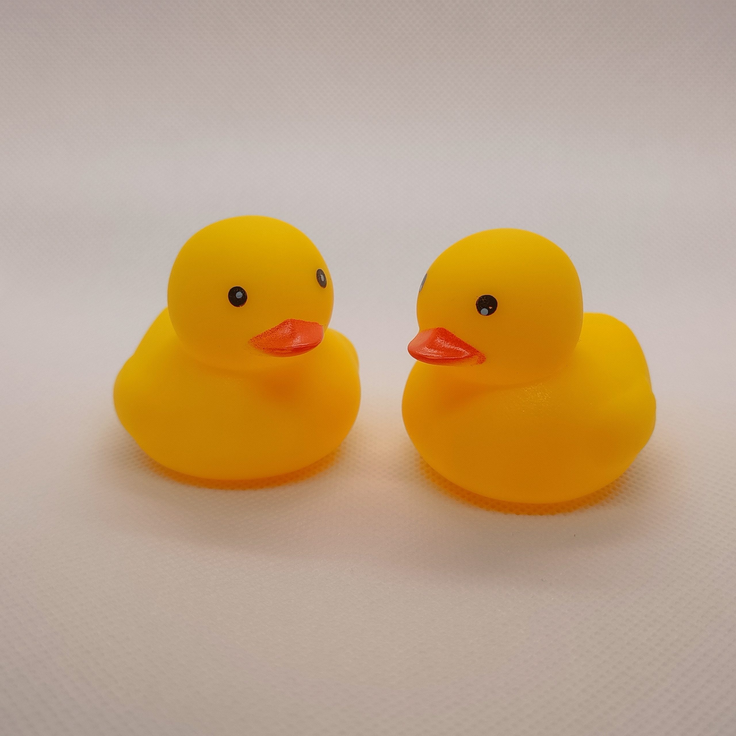 Two,Rubber,Duck,In,The,Middle,Of,A,White,Background